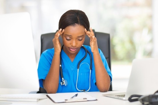 medical employee at desk suffering from burnout