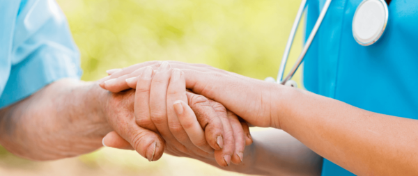 Medical employee holding patients hand